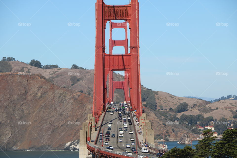 Bridge with lots of traffic on it red vertical metals construction make it stable and visible from far