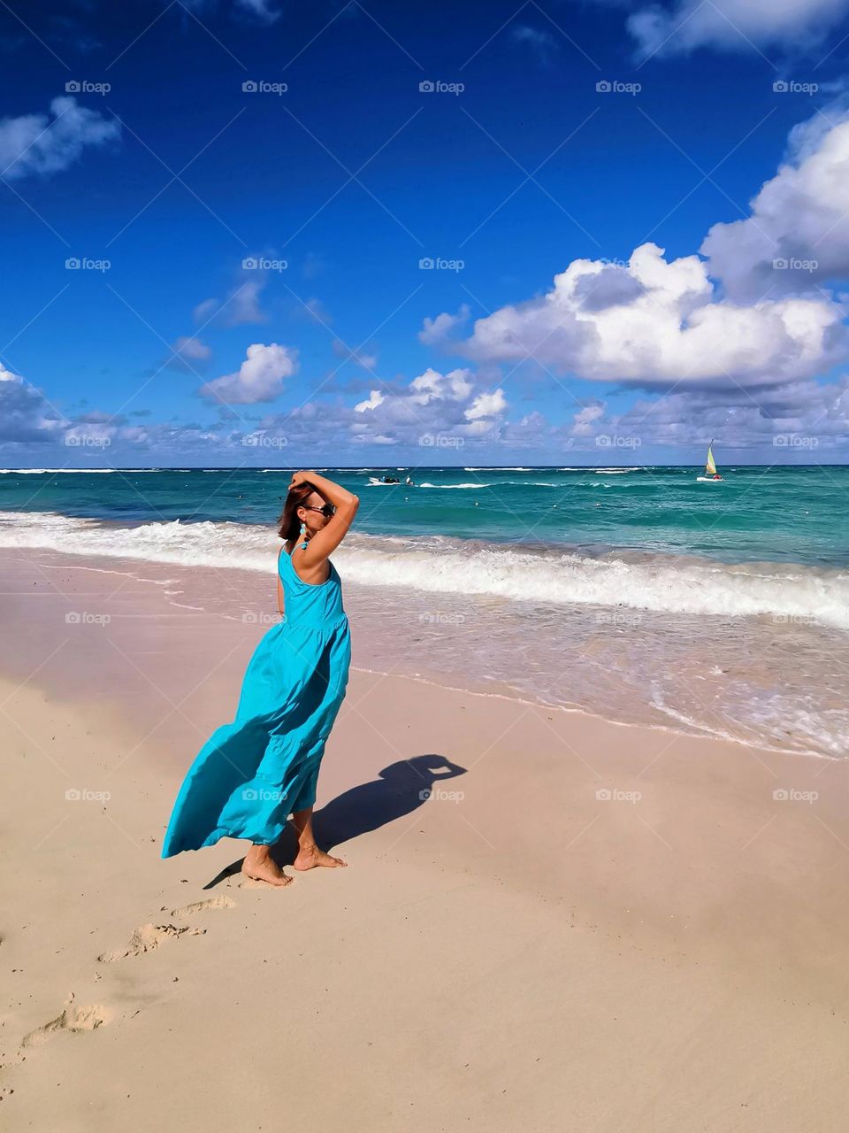 The sea is the best healer and antidepressant. The girl on the seashore enjoys the rest and the beauty of nature. Beautiful memories, and nice moments. Blue dress, blue sea, blue sky. Dominican Republic - paradise place to rest and relax in holiday.