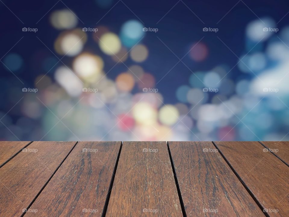 Brown wood board with blurred colorful light background 