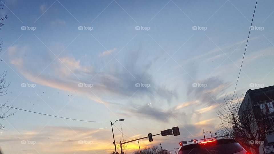 whispy clouds at sunset in traffic