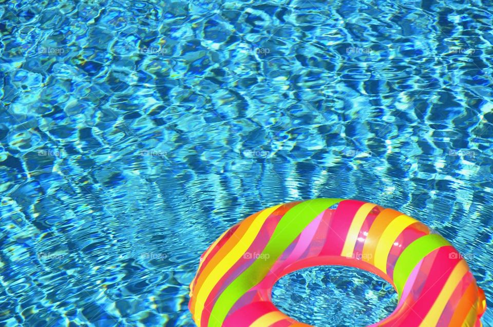 A colorful pool float in a a refreshing cool blue swimming pool.