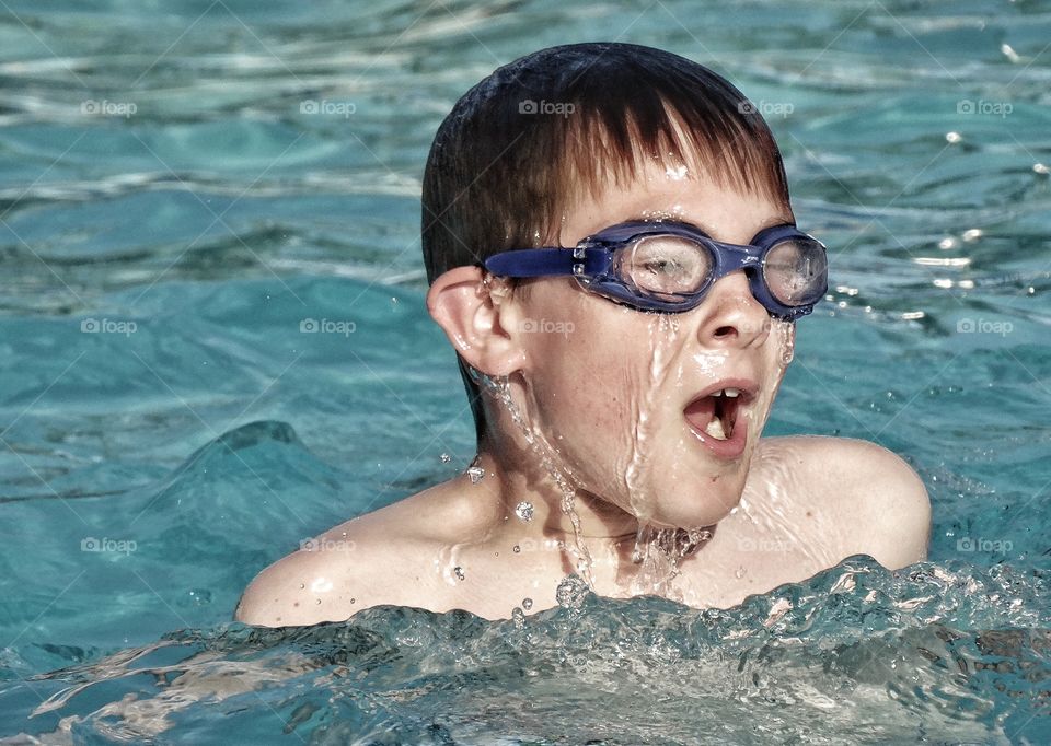 Young Swimmer. Happy Young Boy Learning To Swim
