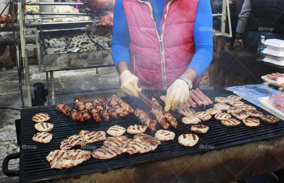 Street barbecue, man preparing meat and sell it