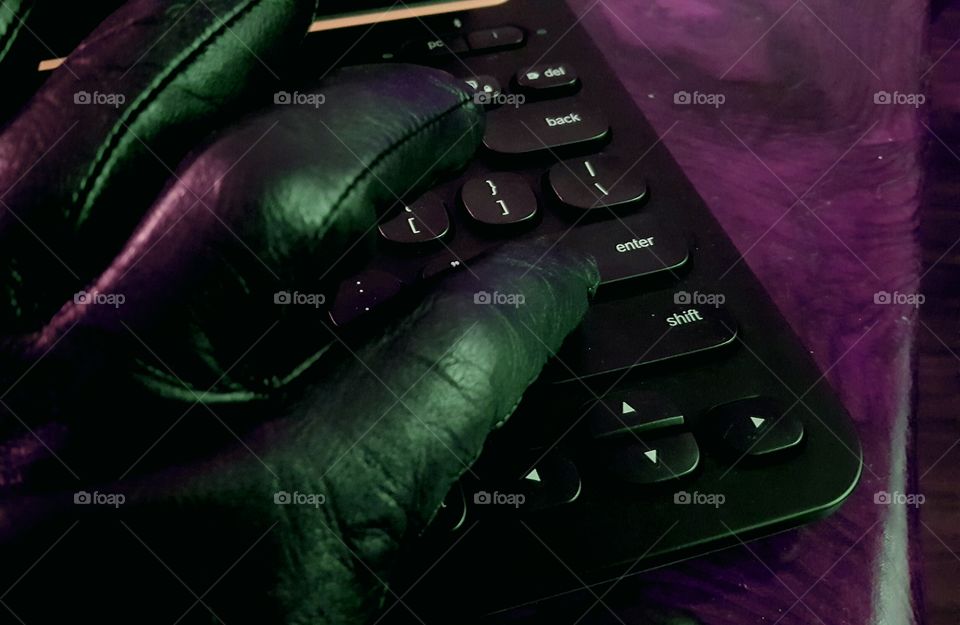 Gloved hand reaches for the Enter key with mood lighting