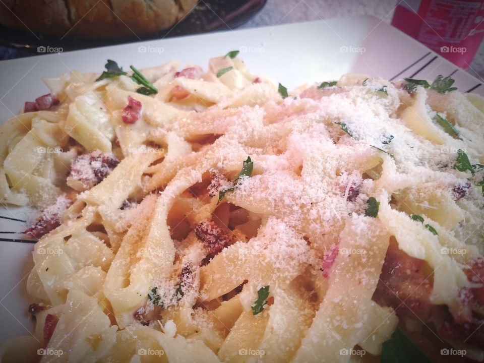 Pasta  Carbonara topped with parmesan cheese and herbs.