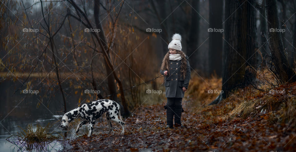 Twins girls with Dalmatian dogs in autumn park 