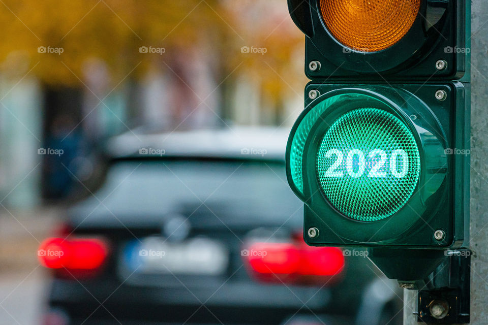 A city crossing with a semaphore. Green light with text 2020 in semaphore. New Year concept