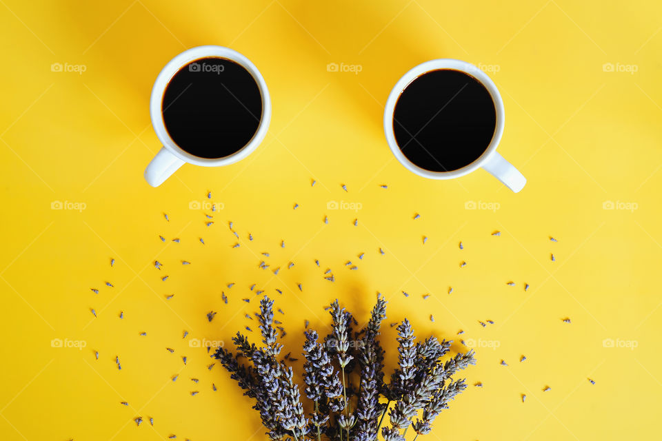 Business working morning with cup of hot coffee, sweet croissant, lavender flowers on yellow background close up. Top view, copy space, flat lay, mockup.