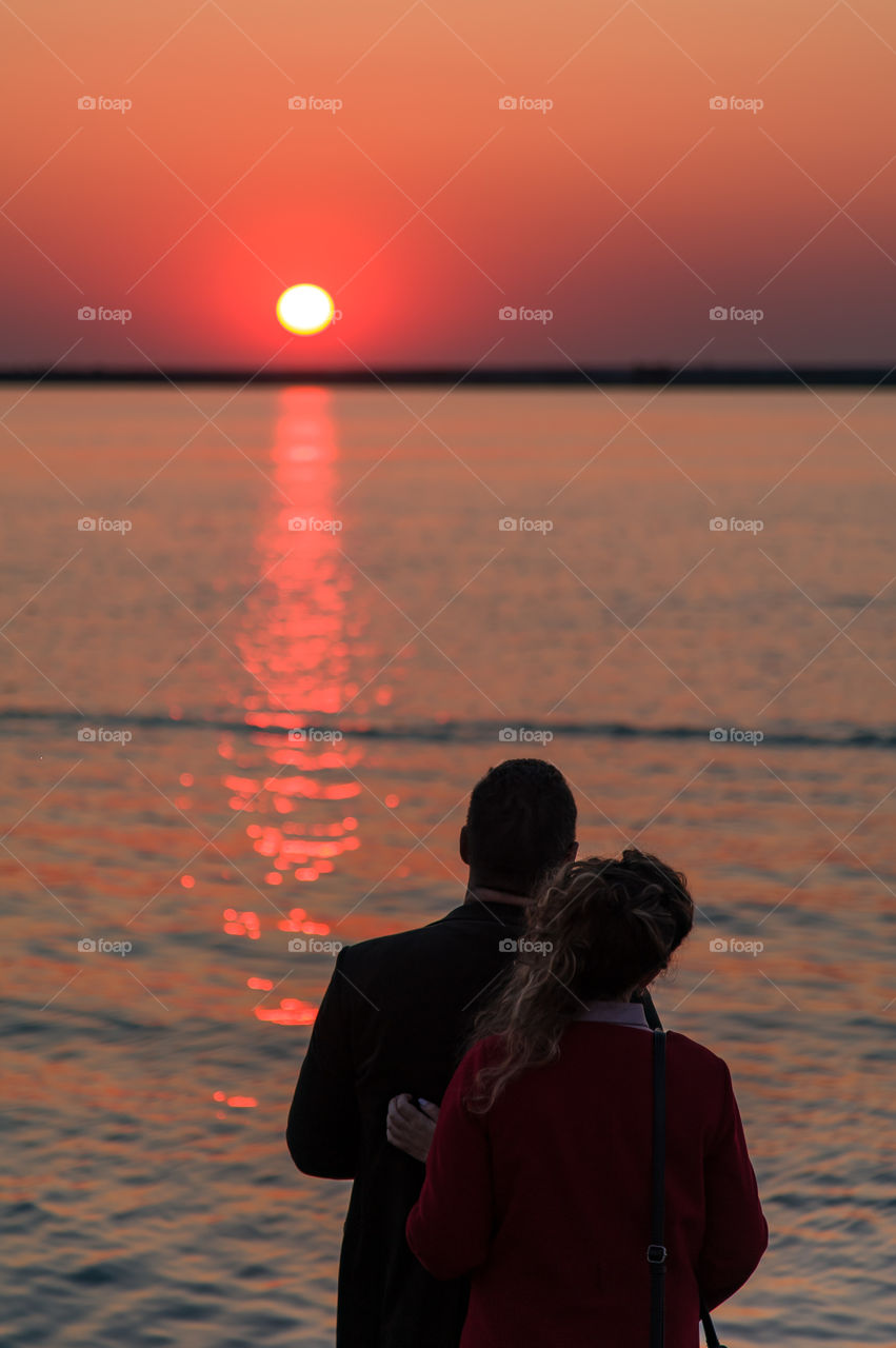 young couple in love admires the sunset on the Black Sea promenade. Crimea Sevastopol