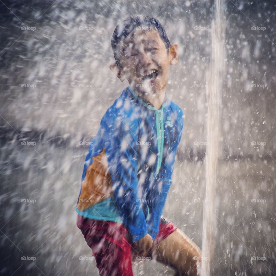 Fountain fun. Boy enjoying the water at Citygate's musical water fountain 