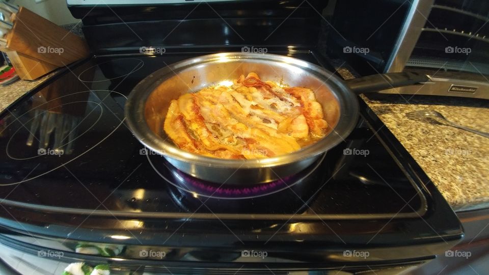 bacon meat strips in pan on stove