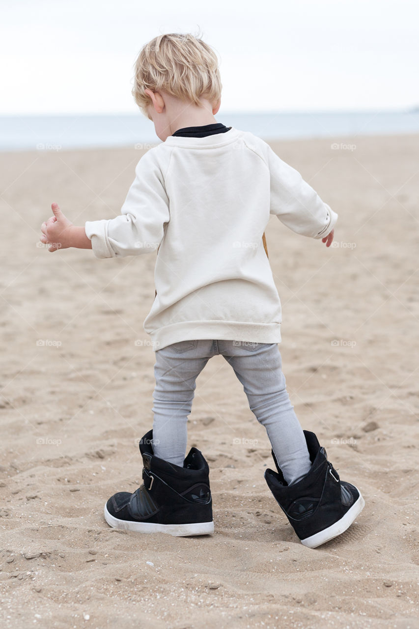A boy walking in his father's shoes
