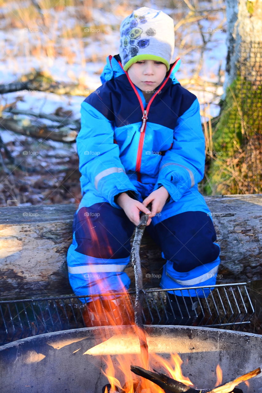 Boy at the open fire outdoors