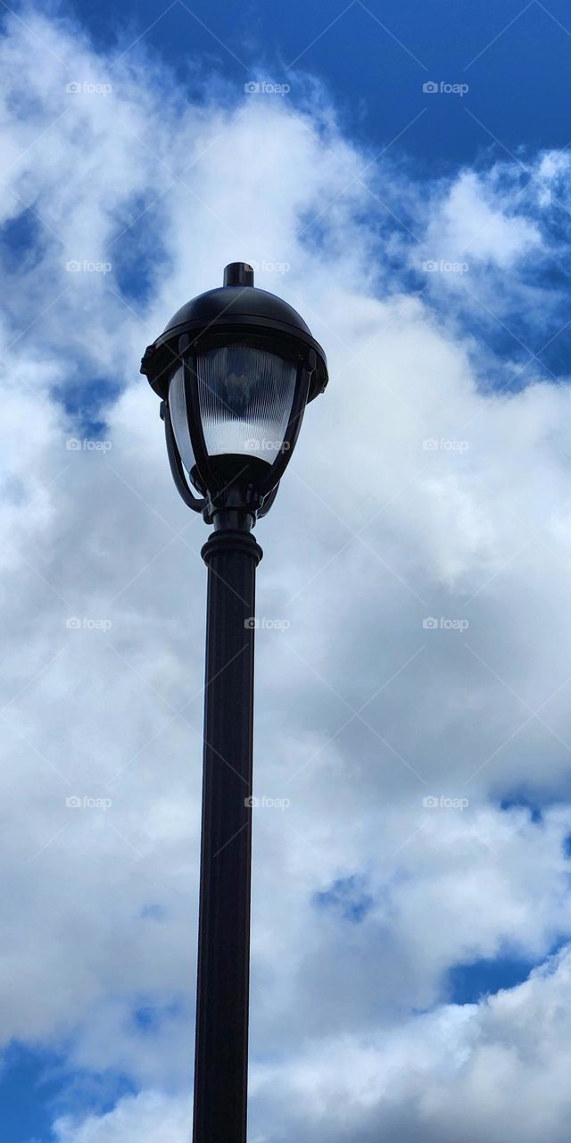 tall lamp post in front of a blue sky and clouds background on a sunny afternoon in Oregon