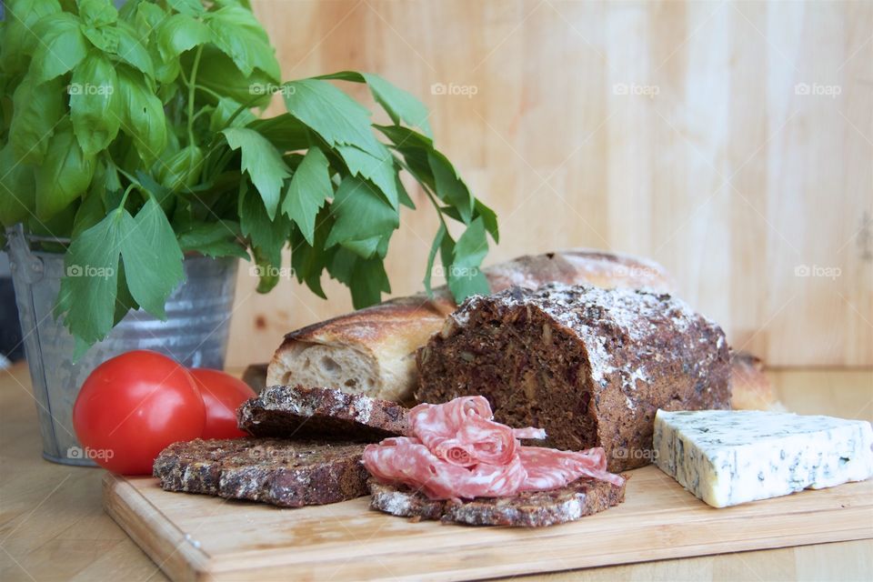 Salami with bread and cheese on table