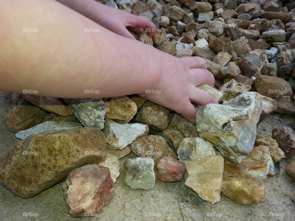 Playing With Rocks. The hands of a boy while he plays with rocks.