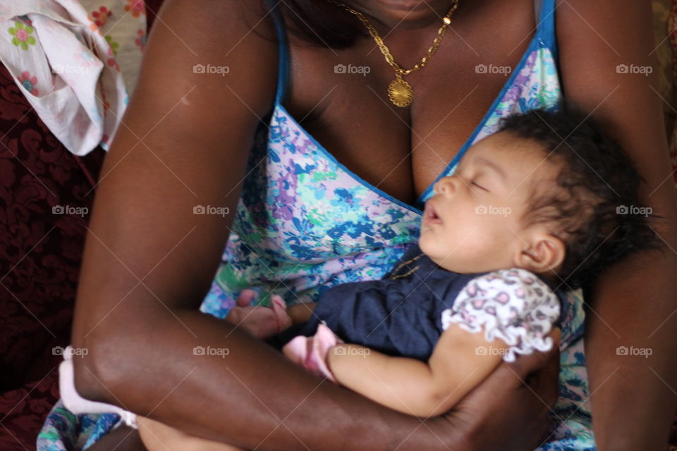 Baby Sleeping. A sleeping baby in a womans arms.