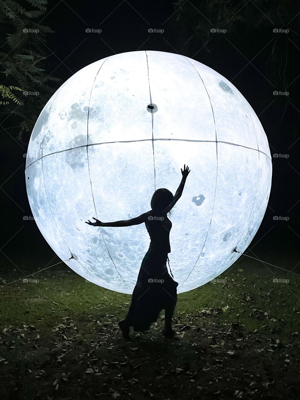 Woman Dances on Front of the Art Installation Moon