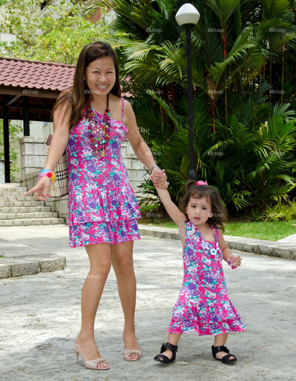 Happy mother and daughter wearing same floral dress