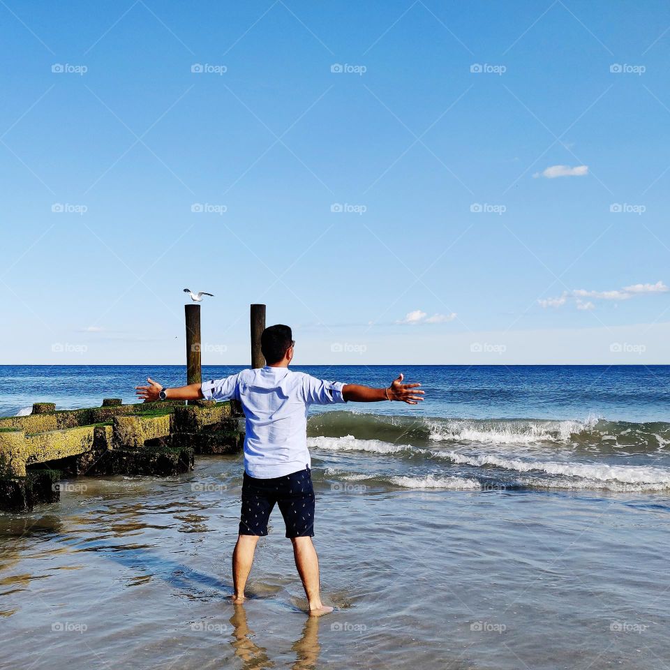 Man Standing At beach Enjoying the Nature & Water