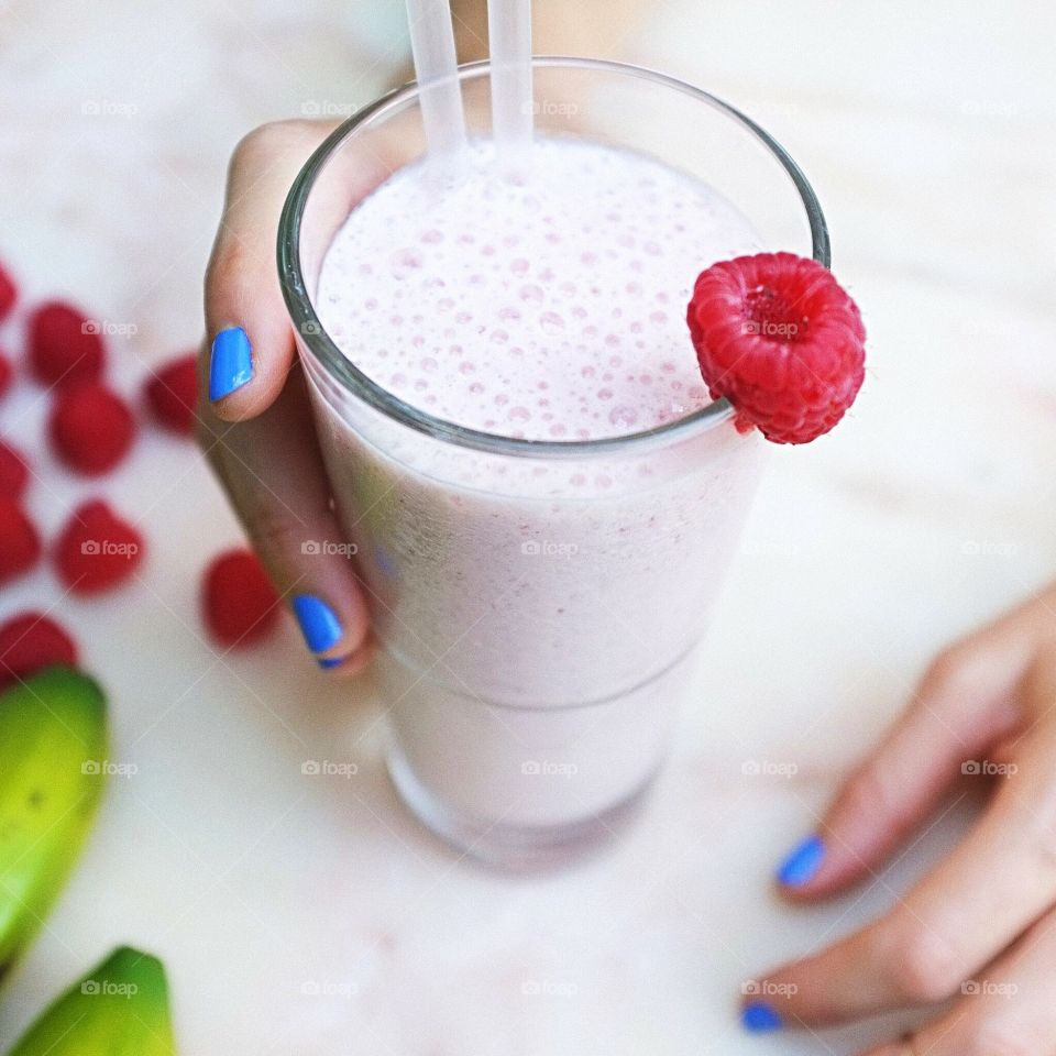 Person holding glass of milkshake