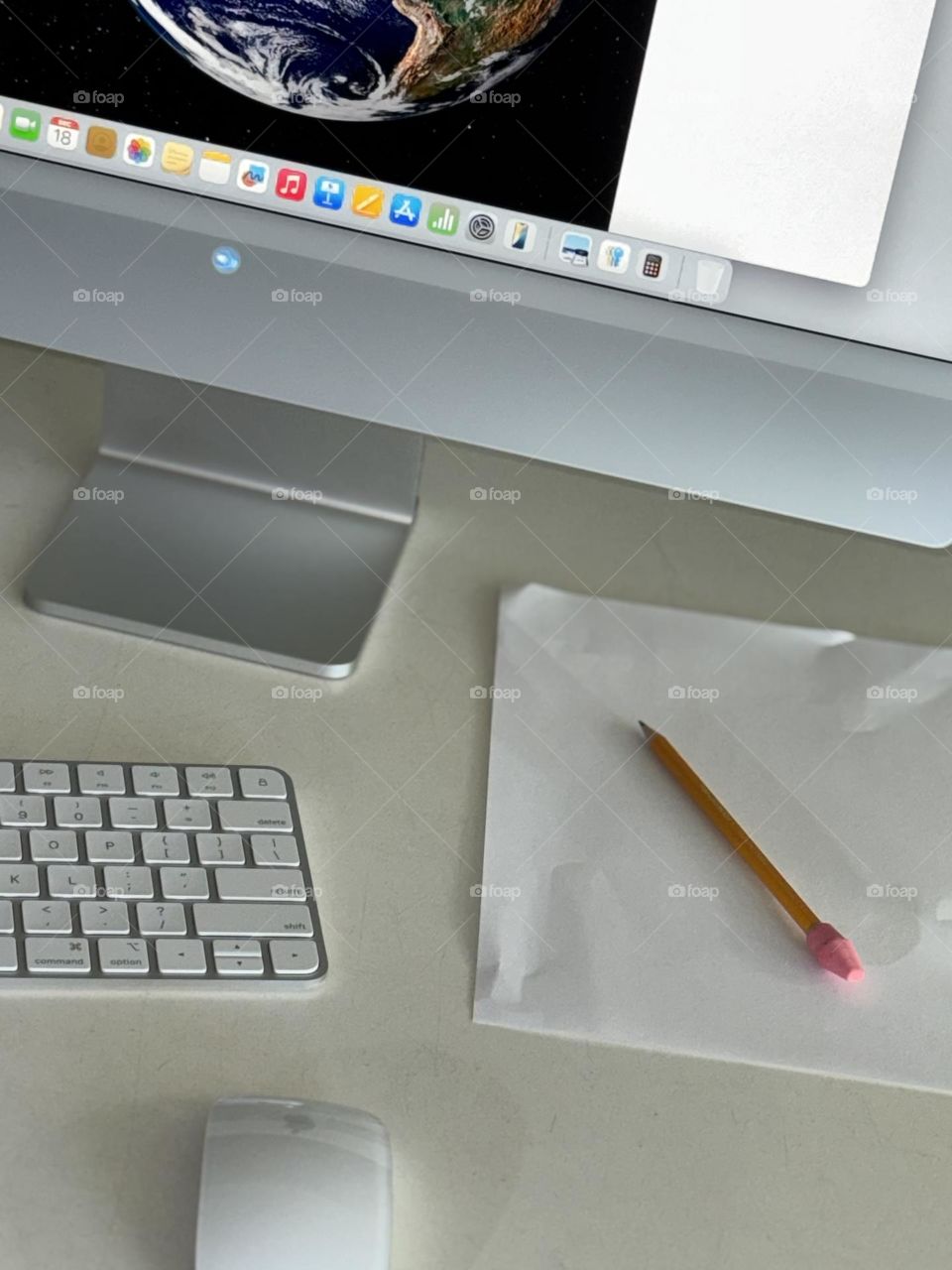 White desktop with iMac keyboard and mouse with sheet of blank paper and pencil with new pink eraser