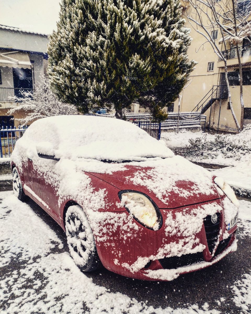 Red car covered in snow. Alfa Romeo MITO. Christmas in Northern Greece.