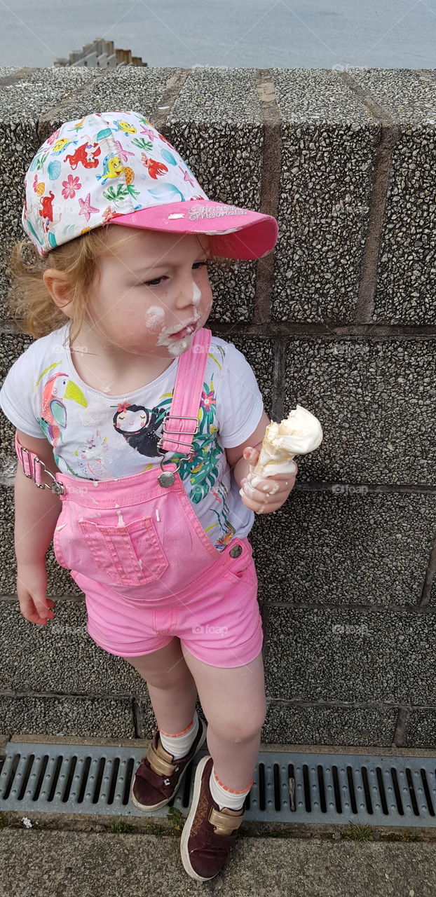 Toddler eating ice cream messily.