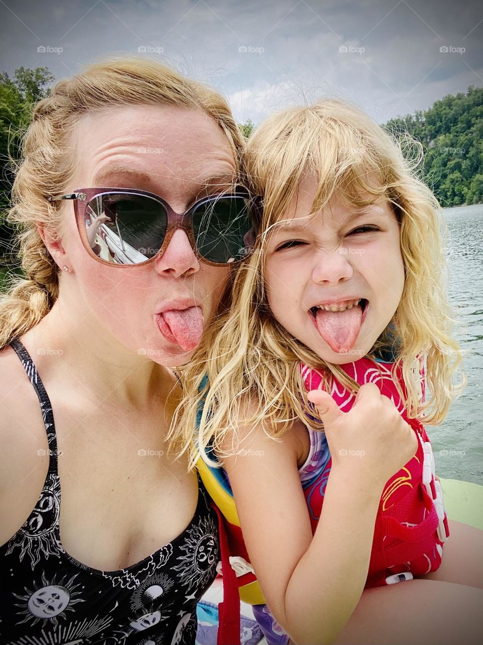 Mother and daughter having summer fun out on a boat 