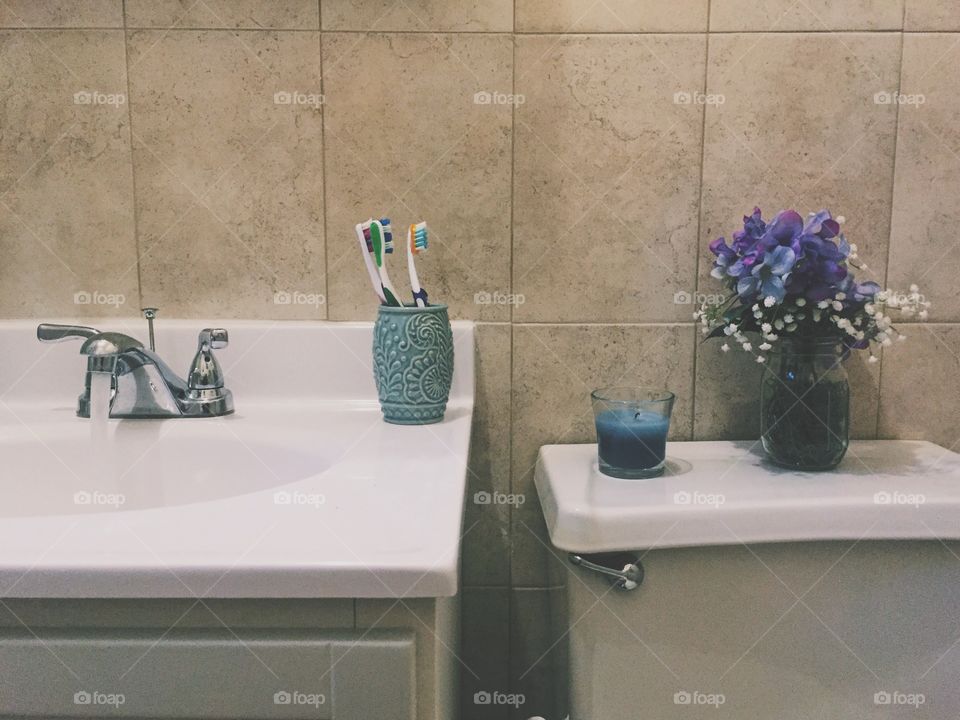 Bathroom with case of flowers and candle
