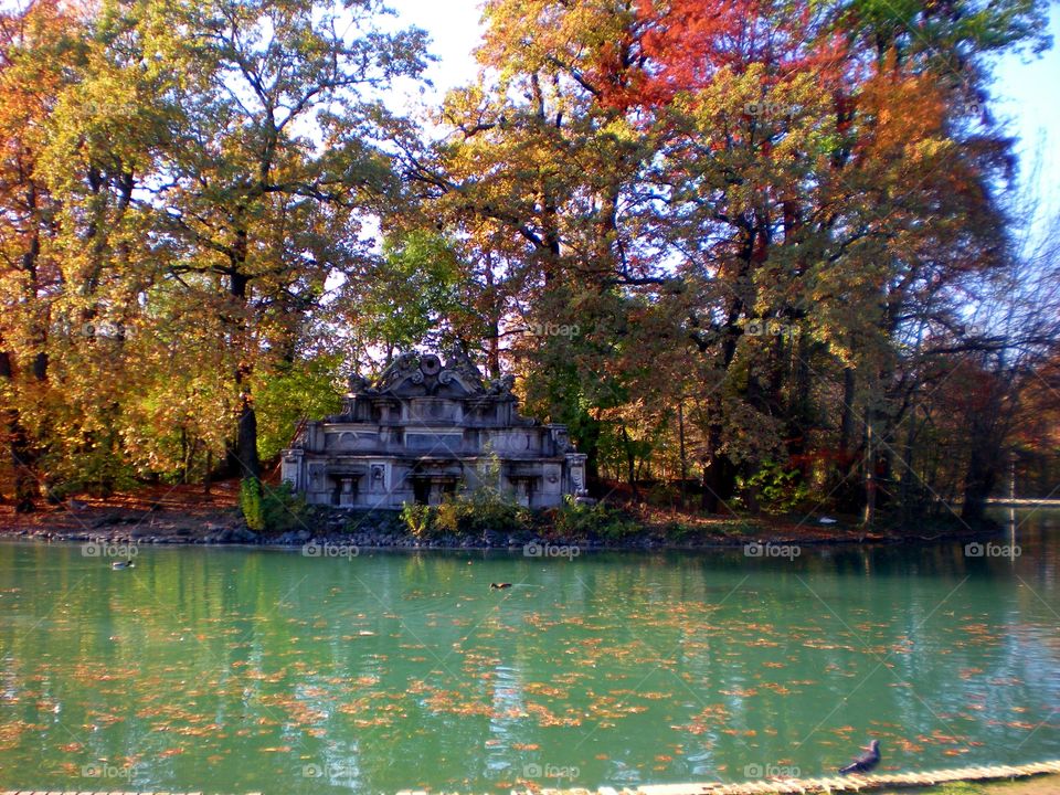 Autumn: little lake with red leaves  in the Parma city Park ( Italy ).