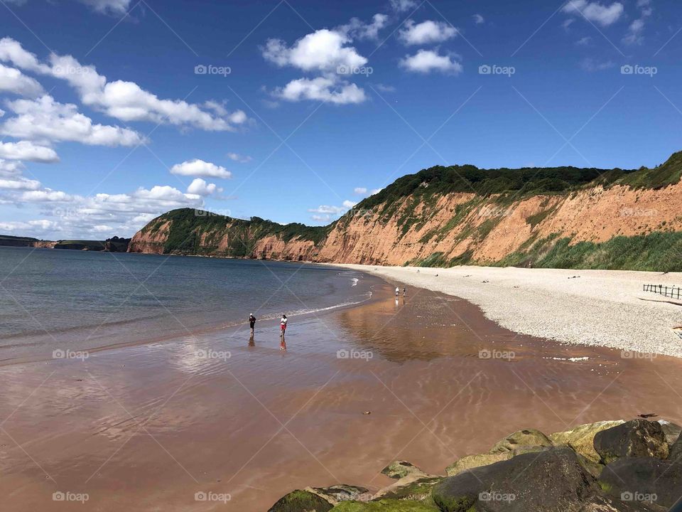 Beach revelers enjoying early summer In Sidmouth, Devon.