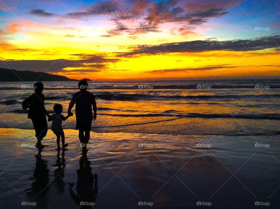 People enjoying at beach during sunset