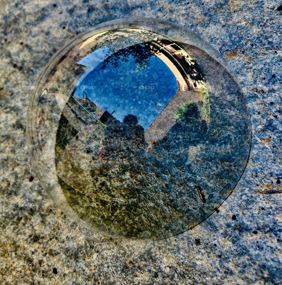 A soap bubble in a circular shape on the table.  What a fun image! / Uma bola de sabão em formato circular sobre a mesa. Que imagem gozada!