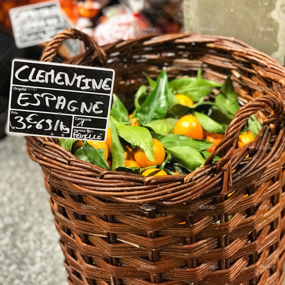 A lovely rustic wooden basket, filled with fresh oranges. Taken in Annecy, France during a a European holiday.  