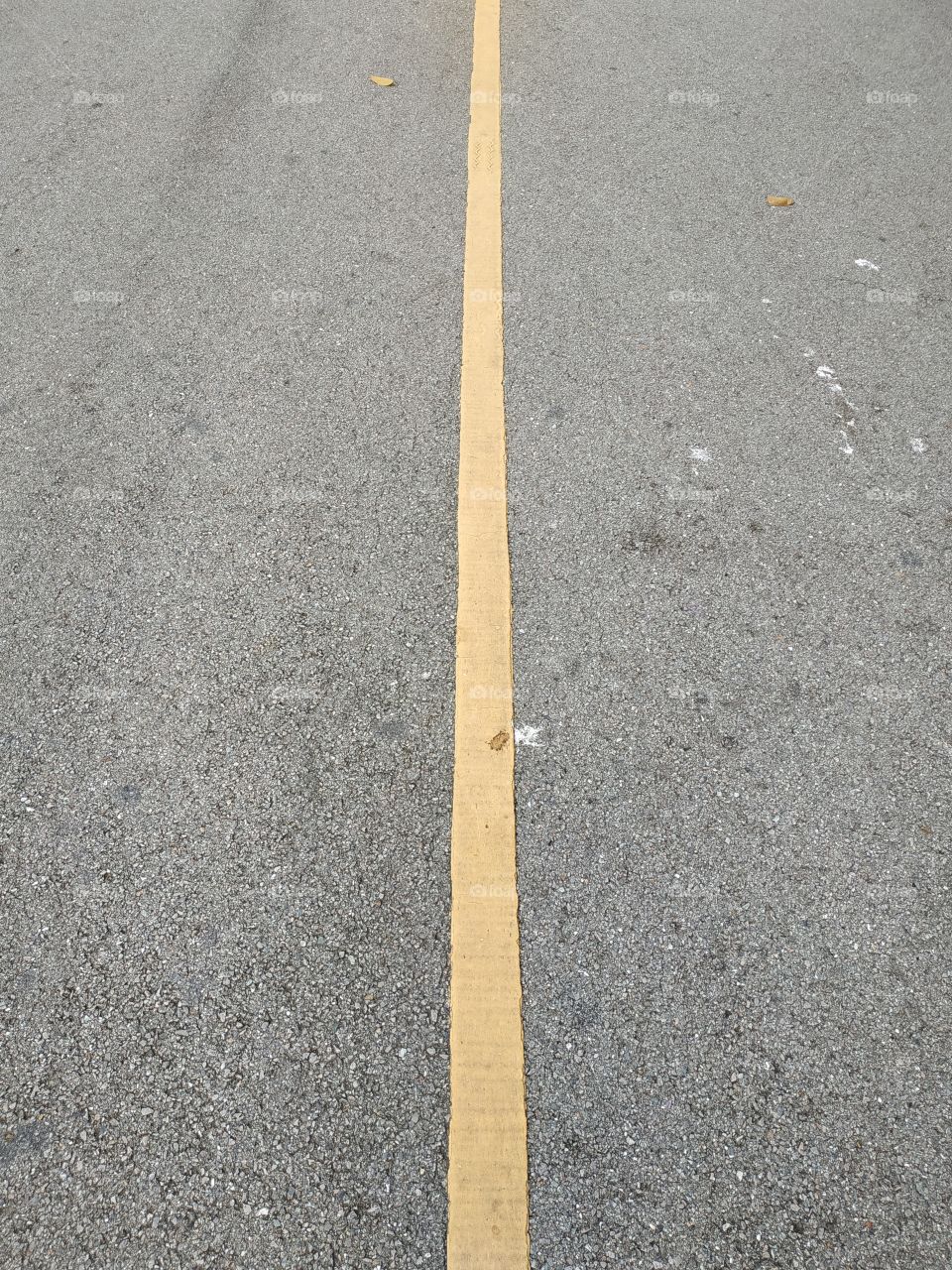 yellow line paint to separate lane on the dirty asphalt street.