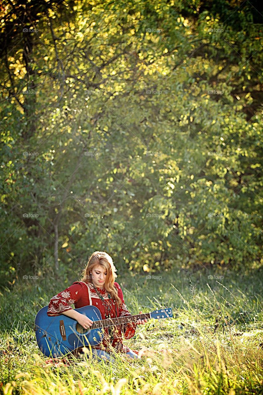 Girl playing guitar outside