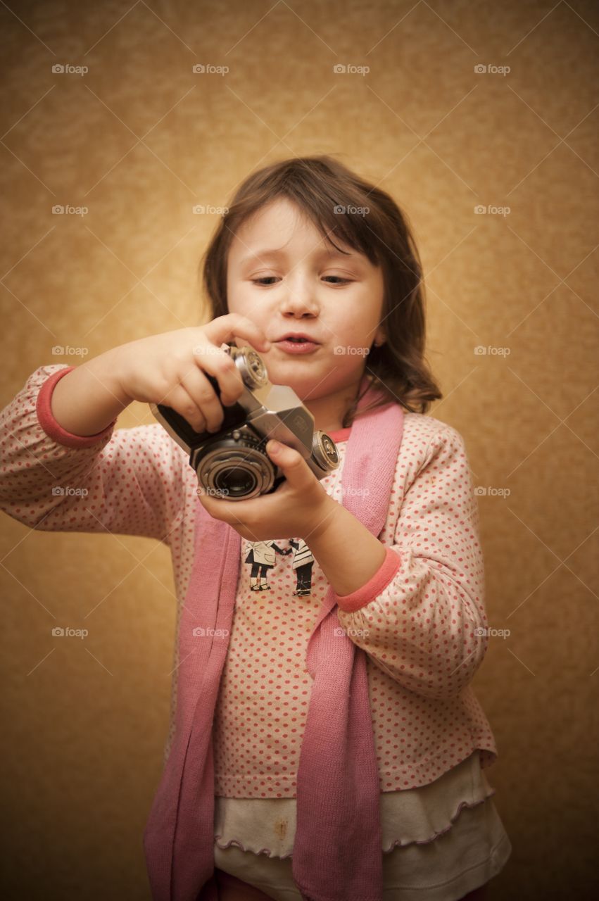 Little cute girl holding camera