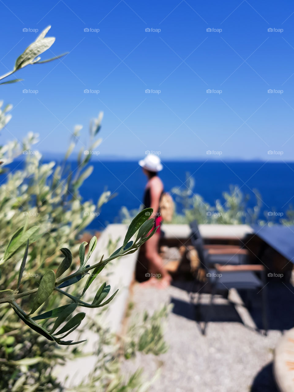 Summertime with blurred seascape and a person looking it.