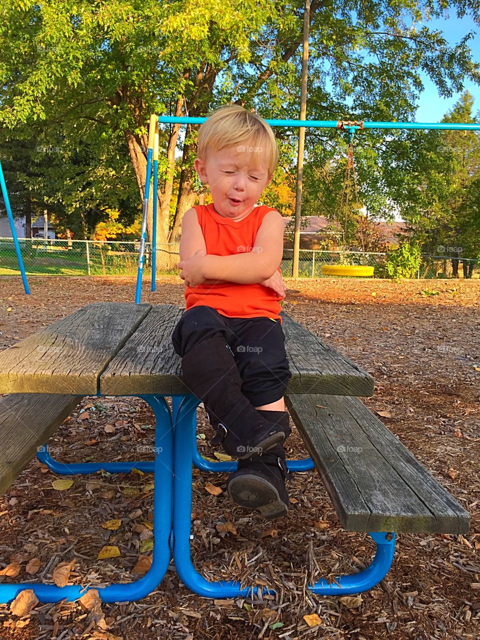 Cute boy sitting on picnic table