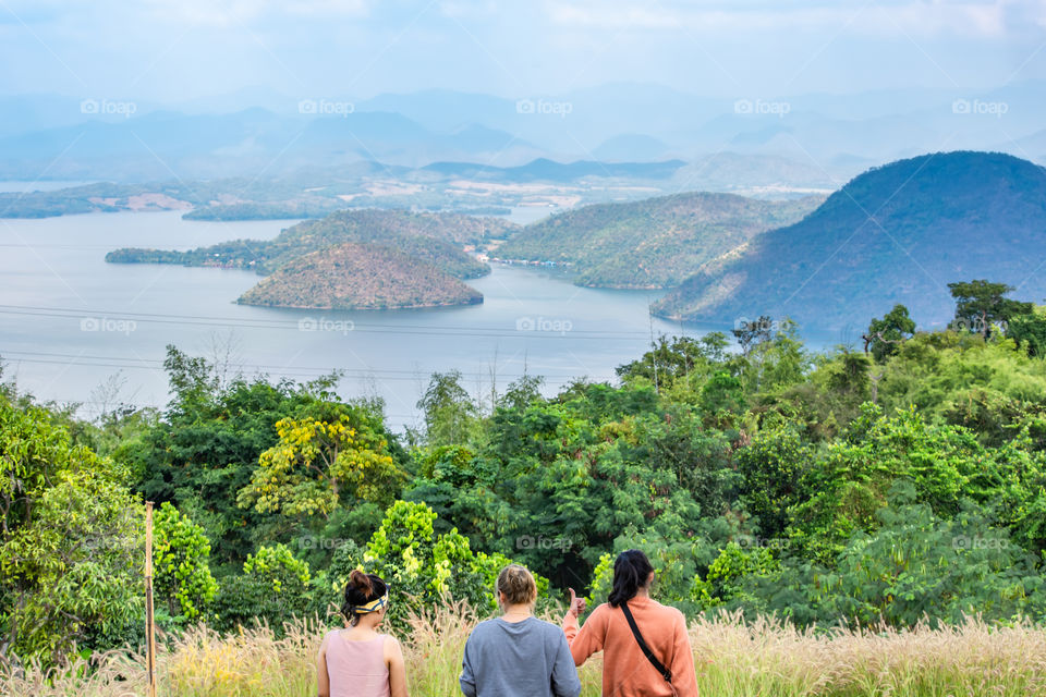 Tourists watch the beauty inside the dam and the houseboat on the bright sky at Sri Nakarin dam , Kanchana buri in Thailand.