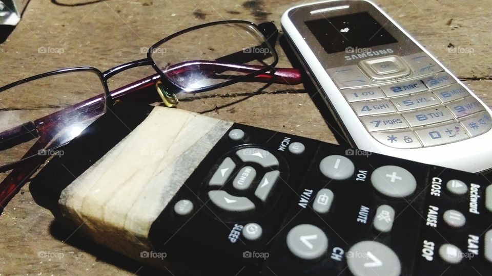 Here's a picture of a broken remote and an old phone and eyeglass.