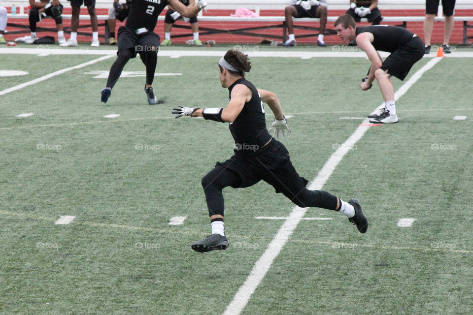 Flying on the field . Football player running during 7 on 7 game