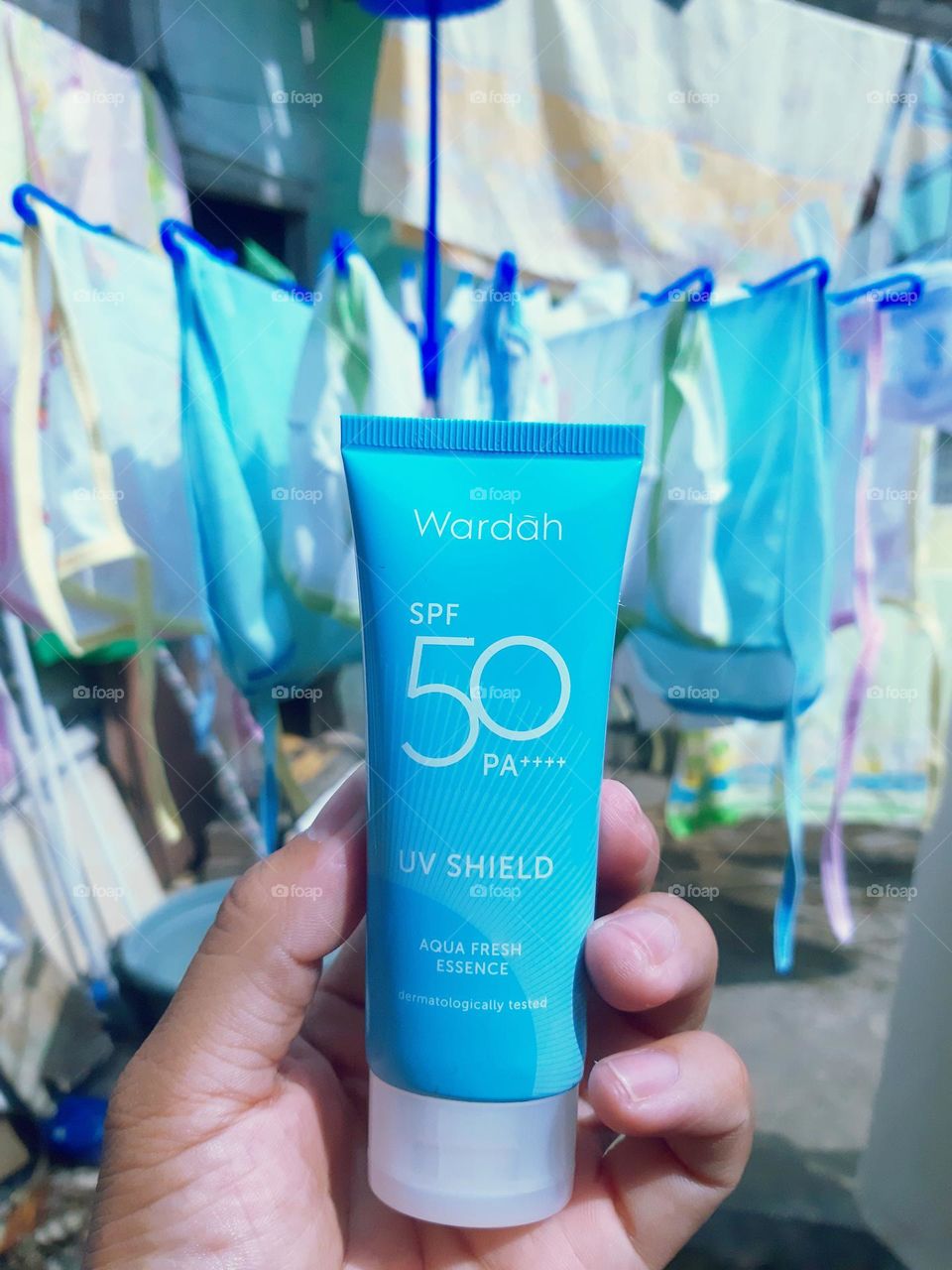 Hands holding beauty products, face shield from UV.