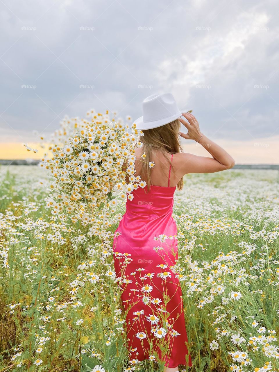 a girl walks in the summer on the window with a large bouquet