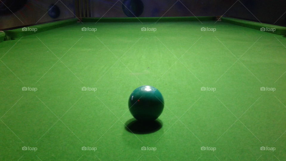 Close-up of green snooker ball on pool table