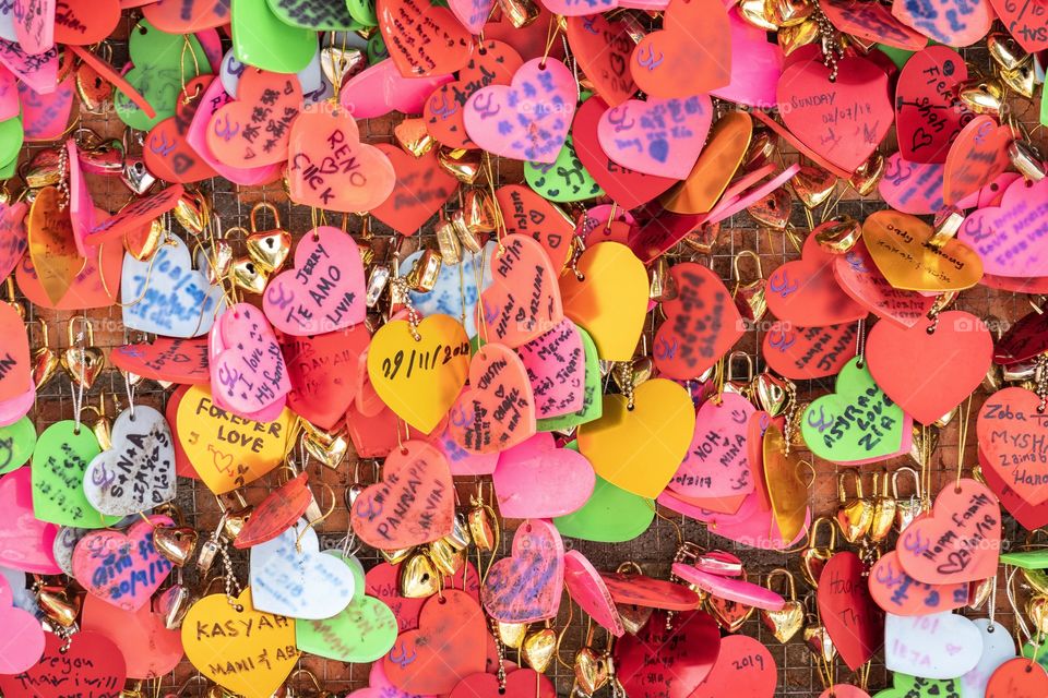 The lovers hangs the colorful little hearts to the wall