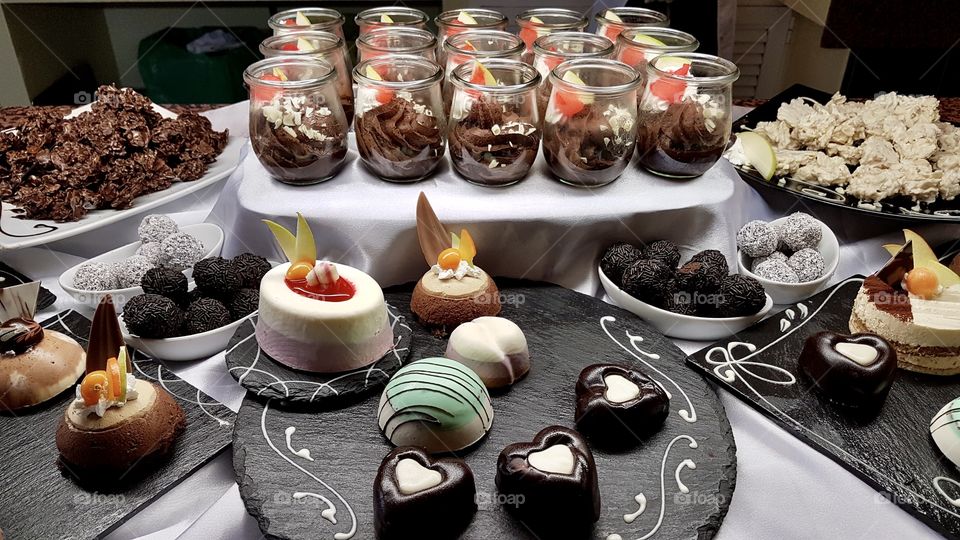 Many different kinds of small delicious desserts and sweets on a table  - många olika goda fina efterrätter bakelser på ett uppdukat bord 
