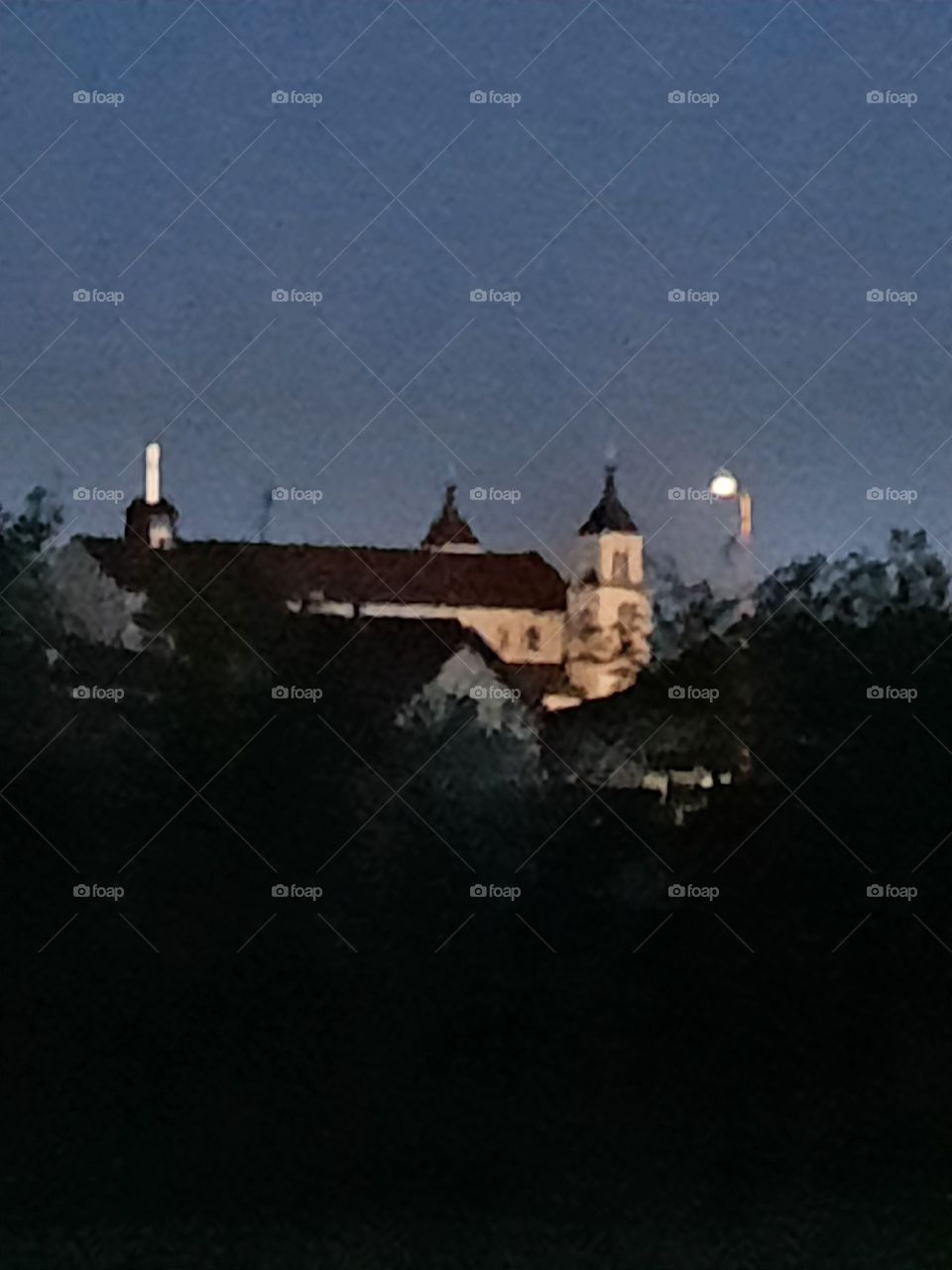 local church and lit street lamp at dusk