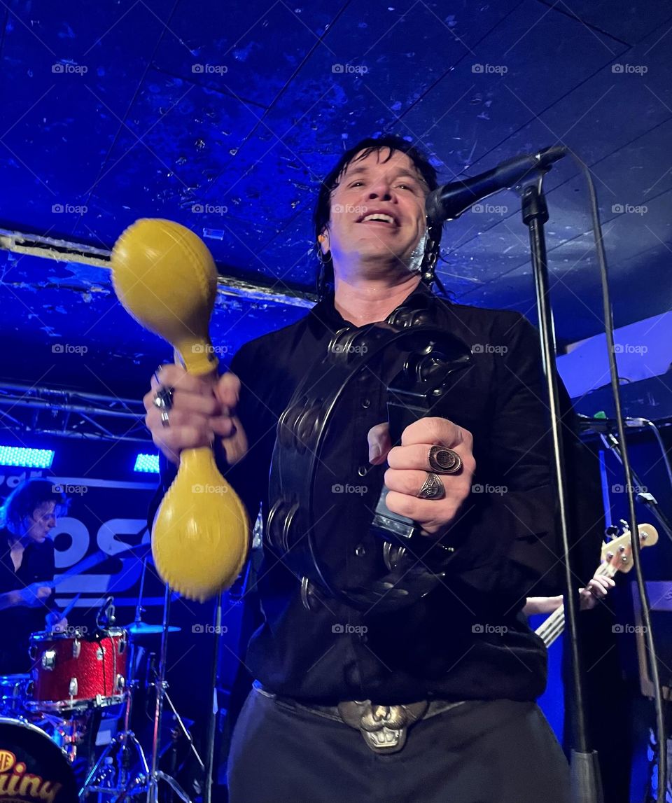 Happy singer in blue light with yellow castanets